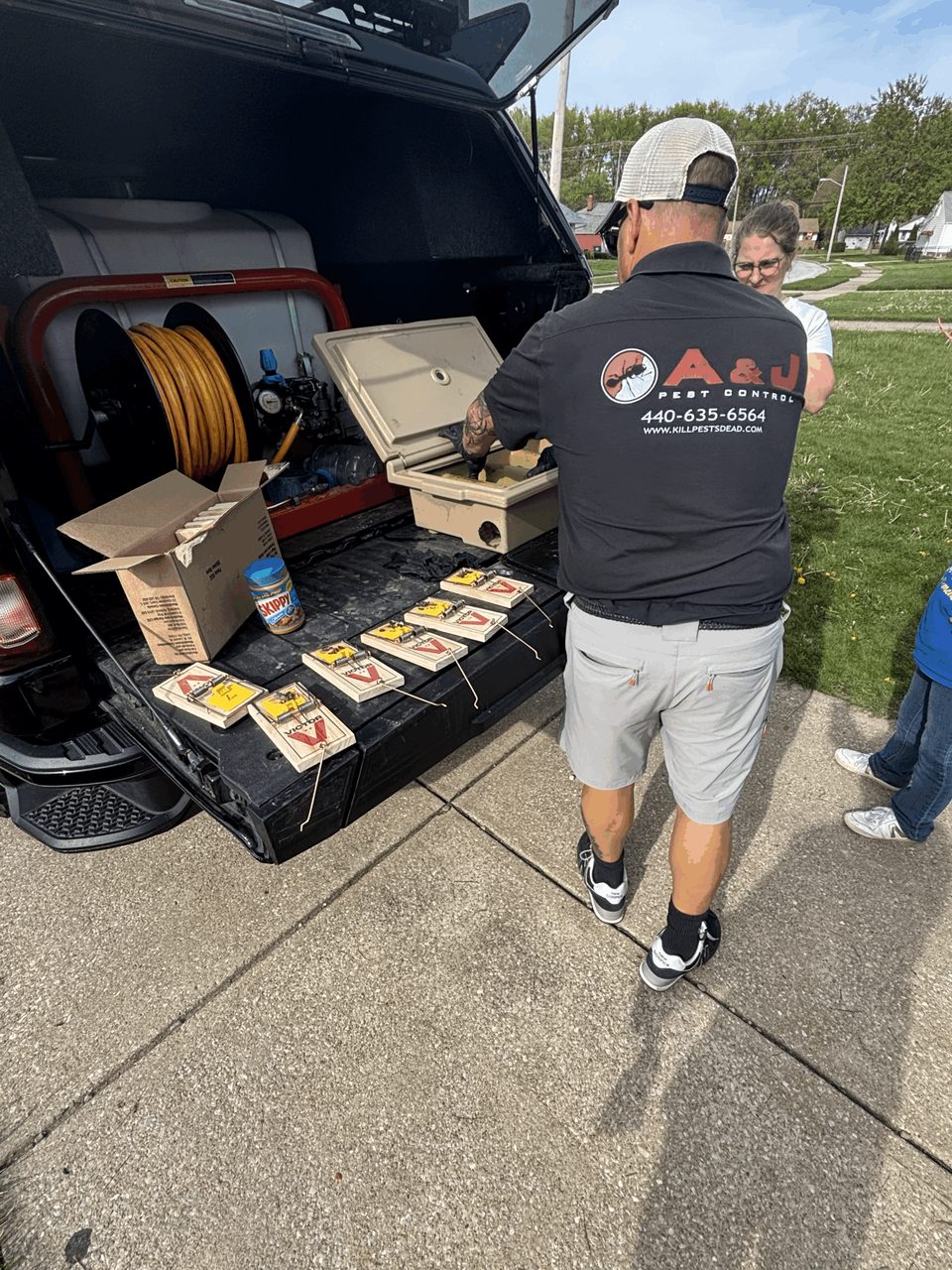 A&J technician baiting mouse traps at the back of the company truck
